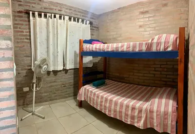a bedroom with two bunk beds and a fan at Cabañas El Descanso in Potrero de Garay