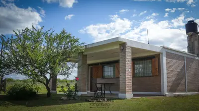 a small brick house with a tree in front of it at Cabañas El Descanso in Potrero de Garay