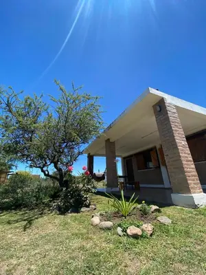 a house with a tree in front of it at Cabañas El Descanso in Potrero de Garay