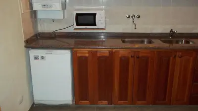 a kitchen with a sink and a microwave at Nuna Ayni Apartments in Alta Gracia