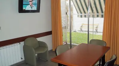a dining room with a table and chairs and a television at Nuna Ayni Apartments in Alta Gracia