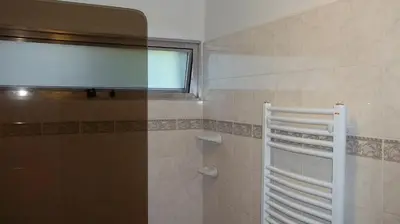 a bathroom with a window and a shower at Nuna Ayni Apartments in Alta Gracia