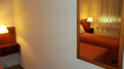 a mirror in a hotel room with a bed and a bedroom at Nuna Ayni Apartments in Alta Gracia