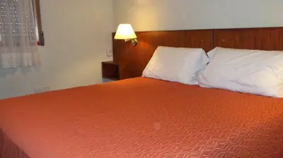 a bedroom with a bed with two pillows and a lamp at Nuna Ayni Apartments in Alta Gracia