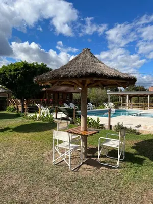 a table and two chairs and a hut next to a pool at BoraBora in Nono