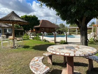 a picnic table and umbrella next to a pool at BoraBora in Nono