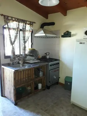 a kitchen with a stove and a sink and a refrigerator at La Casa de Ana in Bialet Massé