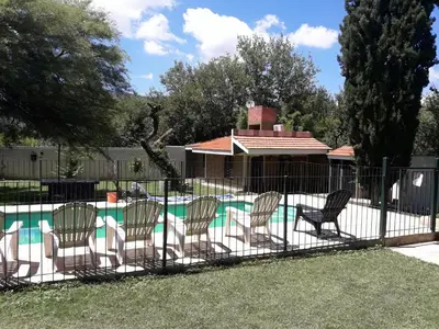 a fence with chairs next to a swimming pool at La Casa de Ana in Bialet Massé