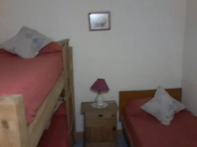 a bedroom with two beds and a table with a lamp at La Casa de Ana in Bialet Massé