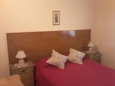 a bedroom with a red bed with two night stands at La Casa de Ana in Bialet Massé