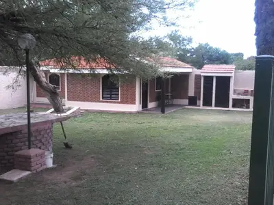 a brick house with a tree and a yard at La Casa de Ana in Bialet Massé