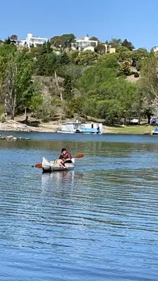 a person in a kayak on a body of water at Gran casa del lago in Villa Ciudad de America