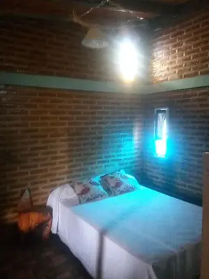 a room with a bed in a brick wall at La Pirca in Nono