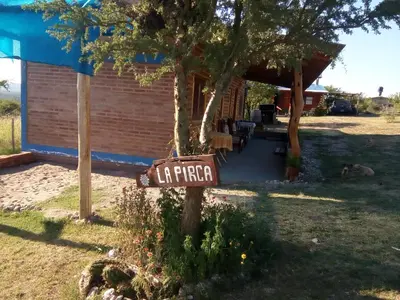 a sign on a tree in front of a house at La Pirca in Nono