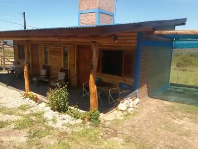 a log cabin with a porch and a patio at La Pirca in Nono