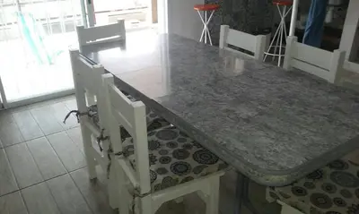 a dining room table with two white chairs and a table at Un Buen Lugar in Villa Parque Siquiman