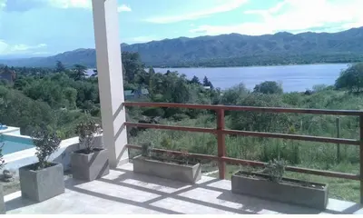 a balcony with potted plants and a view of the water at Un Buen Lugar in Villa Parque Siquiman