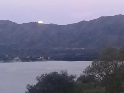 a view of a mountain with the sun rising over the water at Un Buen Lugar in Villa Parque Siquiman