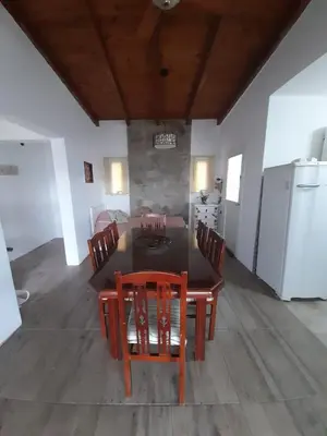 a dining room with a table and chairs and a kitchen at Un Buen Lugar in Villa Parque Siquiman