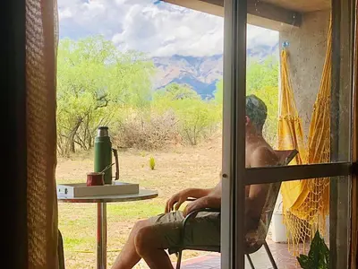 a man sitting in a chair in front of a window at CampoAlto Suites in San Javier