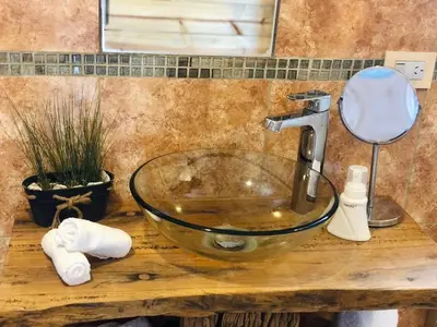 a glass bowl sink on a wooden counter in a bathroom at CampoAlto Suites in San Javier