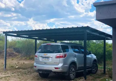 a silver suv parked under a metal structure at CampoAlto Suites in San Javier