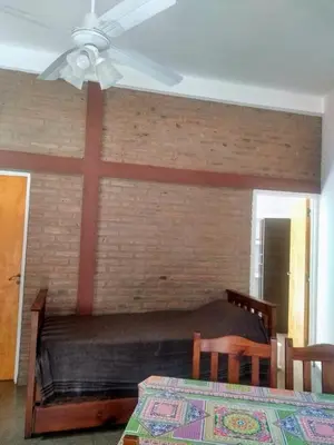 a bedroom with a bed with a large cross on the wall at El Tatu in La Bolsa