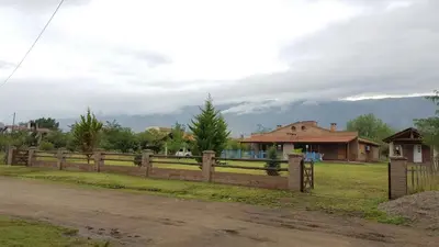 a wooden fence in front of a house at Las casitas del coco in Merlo