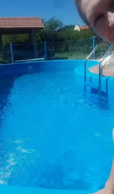 a person is looking at a blue swimming pool at Las casitas del coco in Merlo