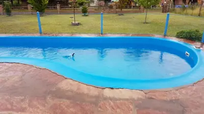 a pool of blue water with a person in it at Las casitas del coco in Merlo