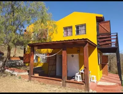 a yellow house with a porch and a deck at Casa en Balcón de Mallín, Mirador del Lago in Bialet Massé