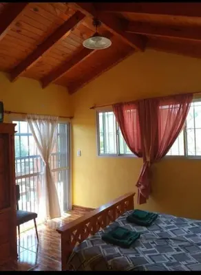 a bedroom with a bed and two windows at Casa en Balcón de Mallín, Mirador del Lago in Bialet Massé