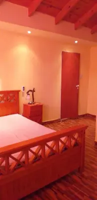 a bedroom with a wooden bed and a wooden door at Casa en Balcón de Mallín, Mirador del Lago in Bialet Massé