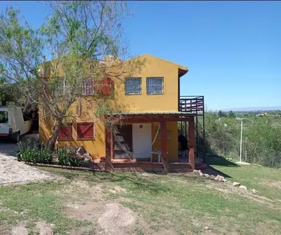 a small yellow house sitting in a field at Casa en Balcón de Mallín, Mirador del Lago in Bialet Massé