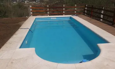 a large blue swimming pool on a deck at Casa en Balcón de Mallín, Mirador del Lago in Bialet Massé