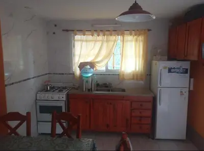a kitchen with a stove and a refrigerator and a window at Casa en Balcón de Mallín, Mirador del Lago in Bialet Massé