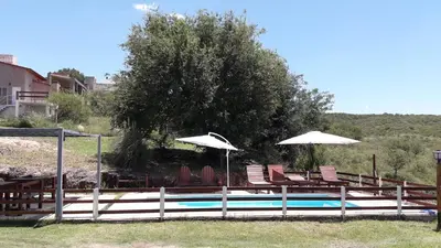 a swimming pool with chairs and umbrellas next to at Terrazas de mayu in Villa Icho Cruz