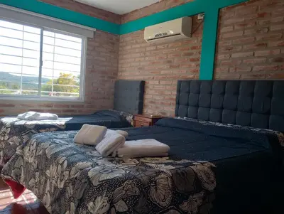 a bedroom with two beds and a large window at Terrazas de mayu in Villa Icho Cruz