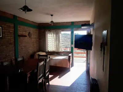 a bedroom with a bed and a table and a window at Terrazas de mayu in Villa Icho Cruz