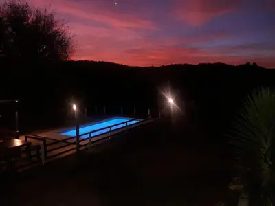 a night view of a swimming pool with two lights at Terrazas de mayu in Villa Icho Cruz
