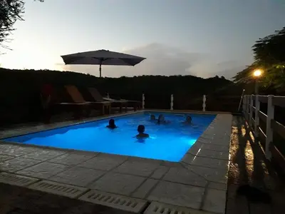 a group of people in a swimming pool at night at Terrazas de mayu in Villa Icho Cruz