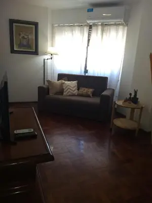 a living room with a couch in front of a window at Excepcional dpto frente a Plaza de la Intendencia in Cordoba