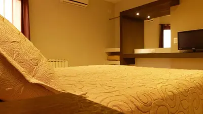 a bedroom with a bed and a tv and a mirror at Casa Decla in Villa Carlos Paz