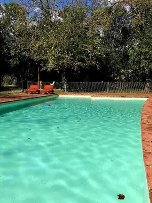 a pool of blue water with two chairs in it at Posada El Cortijo in San Javier