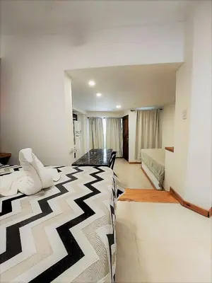 a bedroom with a bed with a black and white blanket at Soles Blancos Serranita in Alta Gracia
