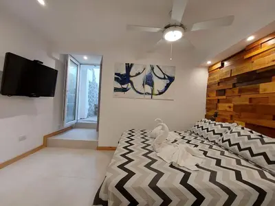 a bedroom with a bed and a flat screen tv at Soles Blancos Serranita in Alta Gracia