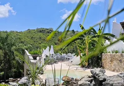 a resort with a pool and chairs and trees at Soles Blancos Serranita in Alta Gracia
