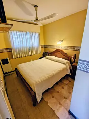 a bedroom with a bed and a ceiling fan at Apart Hotel RITZ in Villa Carlos Paz