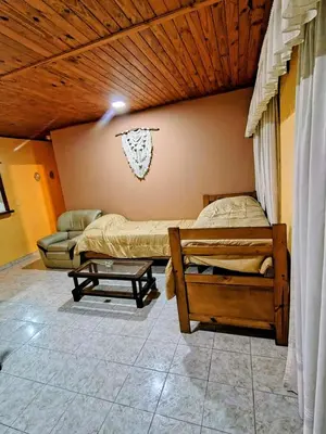 a bedroom with two beds and a couch at Apart Hotel RITZ in Villa Carlos Paz
