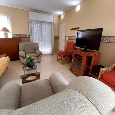 a living room with a couch and a flat screen tv at Apart Hotel RITZ in Villa Carlos Paz